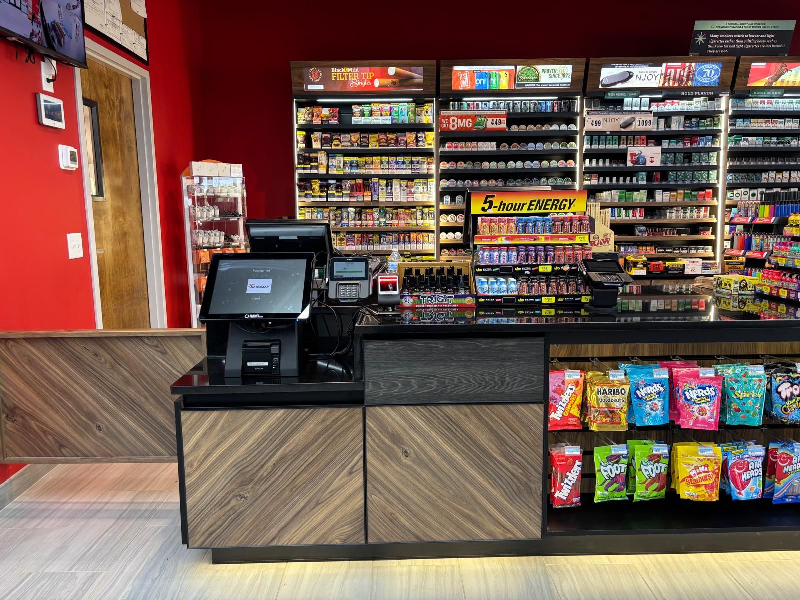 The self-checkout station beside the candy shelves at the front counter