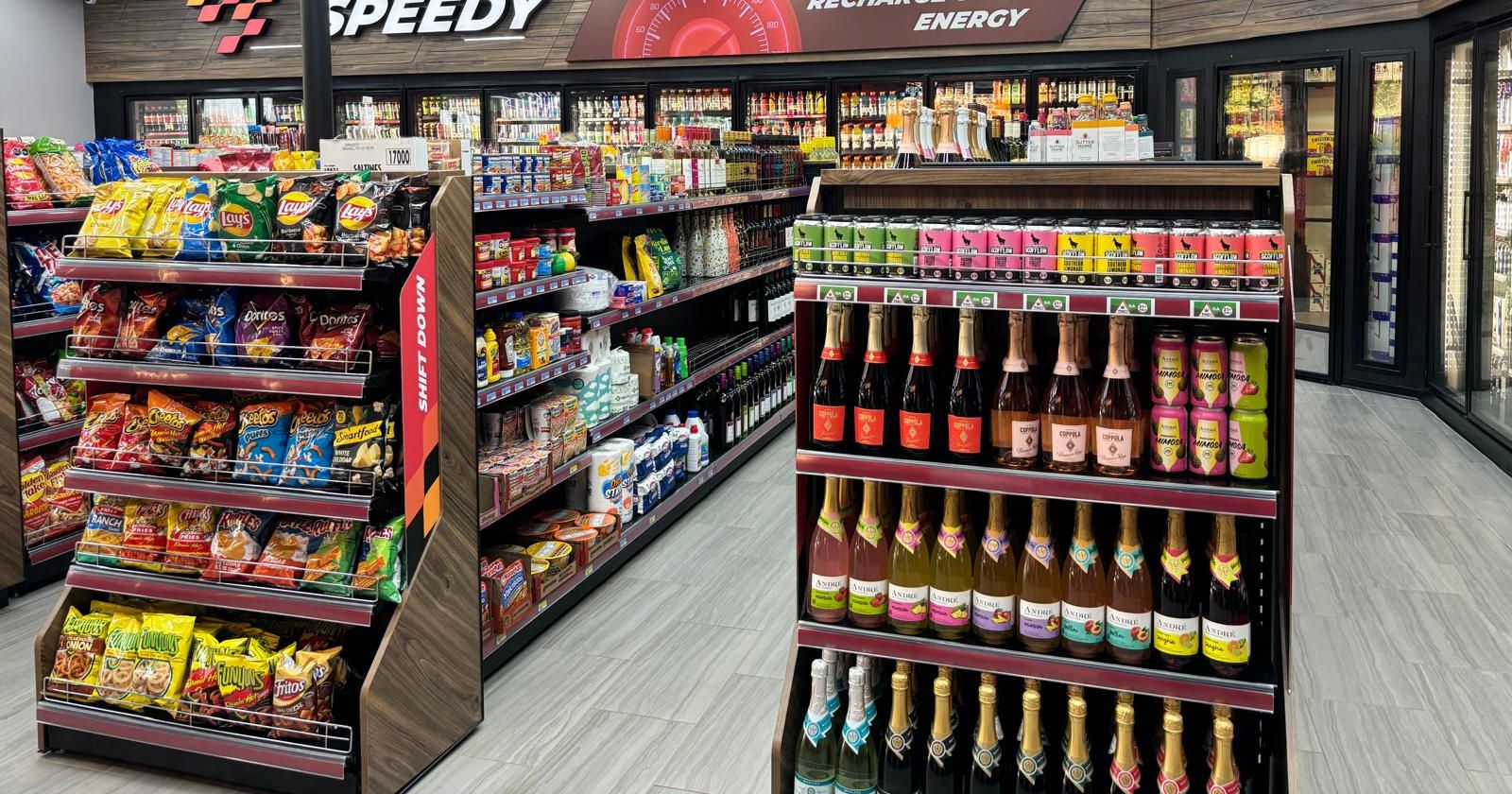 Snack aisles with chips and candy on angled shelves, and a wine end cap
